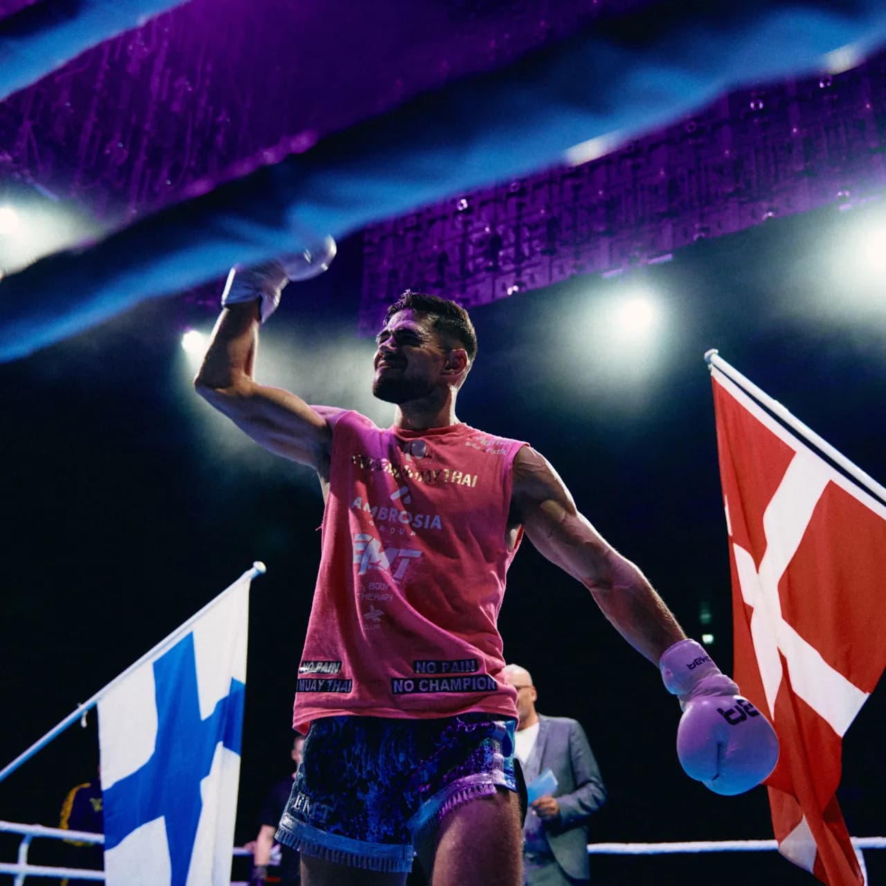 A KOMBA fighter in the ring, flags raised after the bout